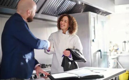 Manager accueillant un nouvel employé dans un restaurant avant le service