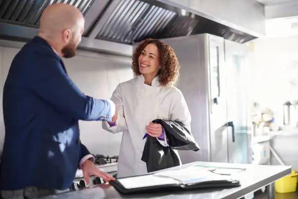 Manager accueillant un nouvel employé dans un restaurant avant le service