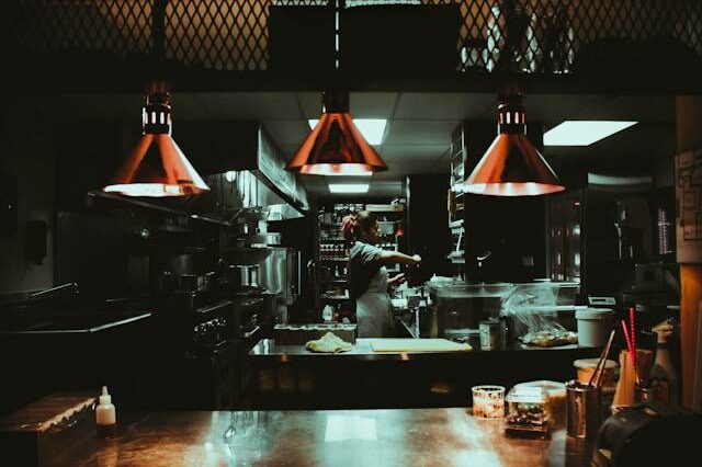 Belle photo, ambiance cuisine professionnelle, très bien pour cet article sur le turnover. Texte alternatif (ALT) Cuisinier seul en cuisine de restaurant la nuit, turnover CHR